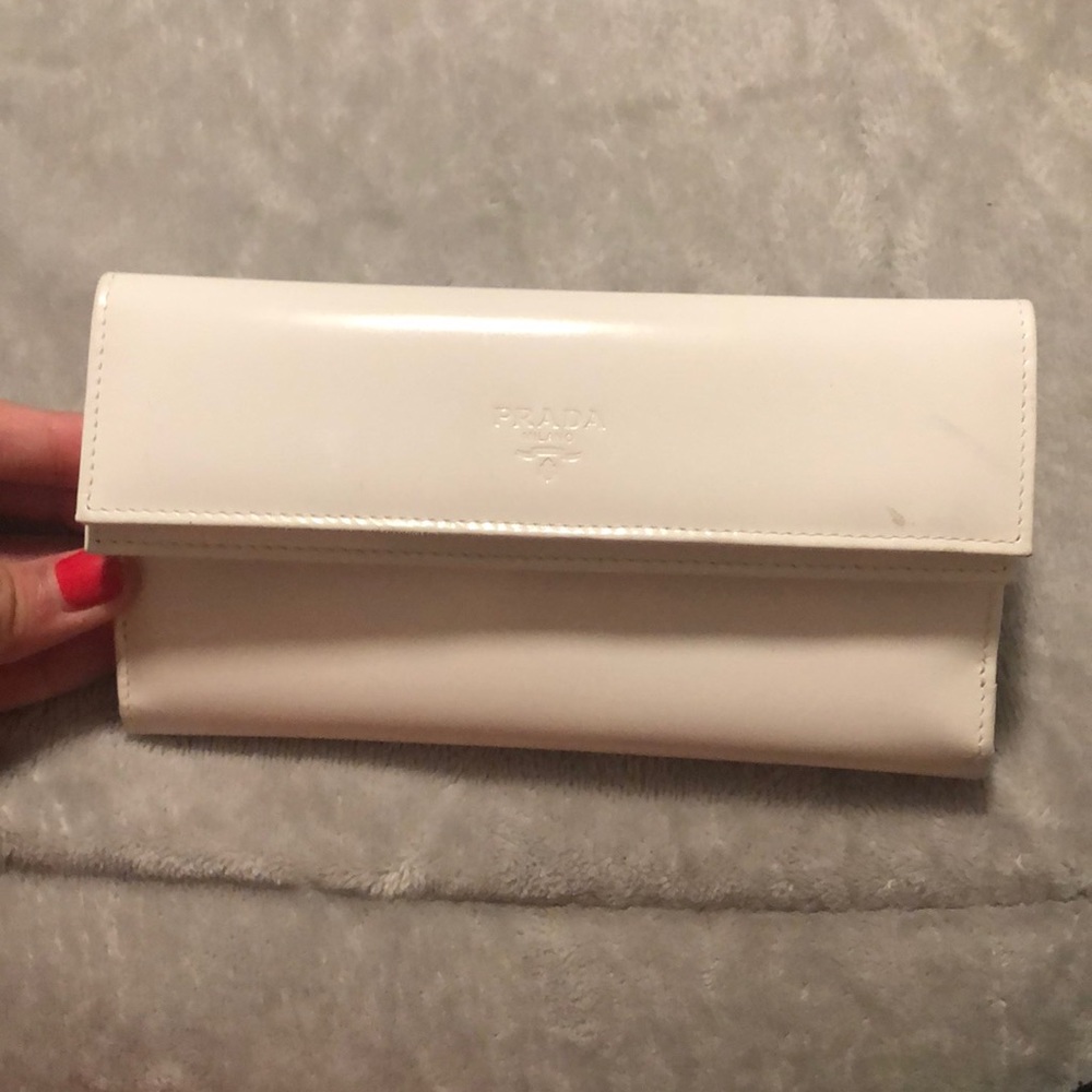 Off white leather Prada close wallet in great condition.  With lots of pockets